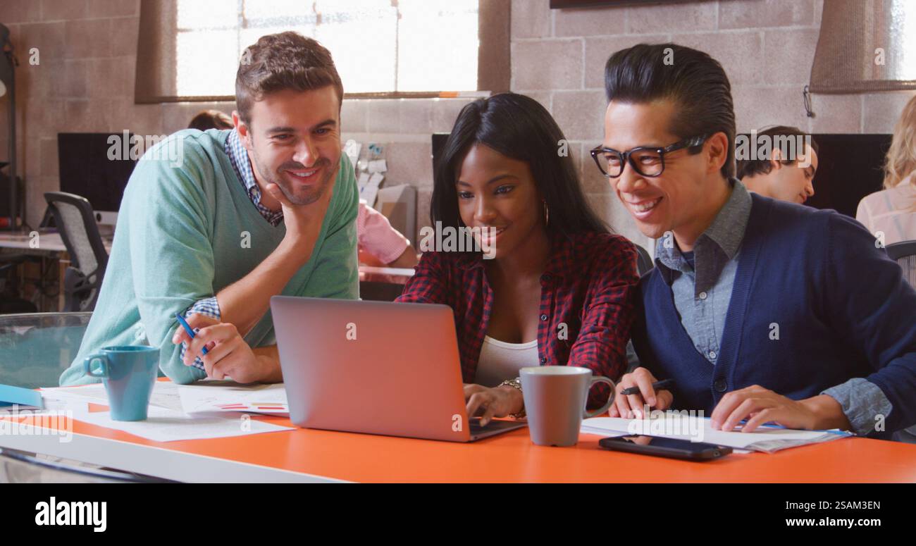 Tre designer in Creative Business che utilizzano laptop Meeting in un moderno ufficio multiculturale Foto Stock