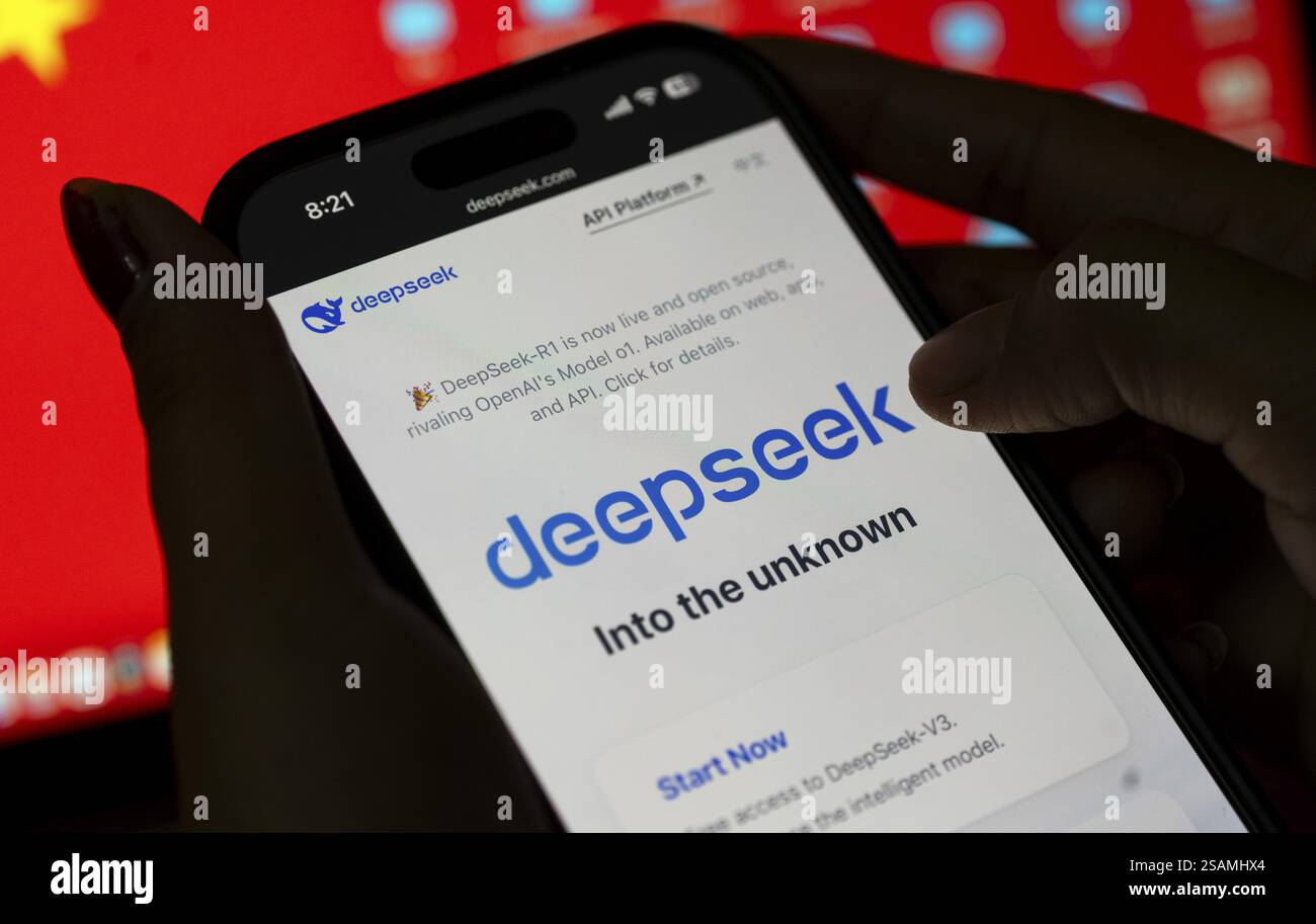 In questa immagine, il logo dell'app DeepSeek cinese appena lanciata viene visualizzato sullo schermo di un iPhone davanti alla bandiera cinese visualizzata su Januar Foto Stock