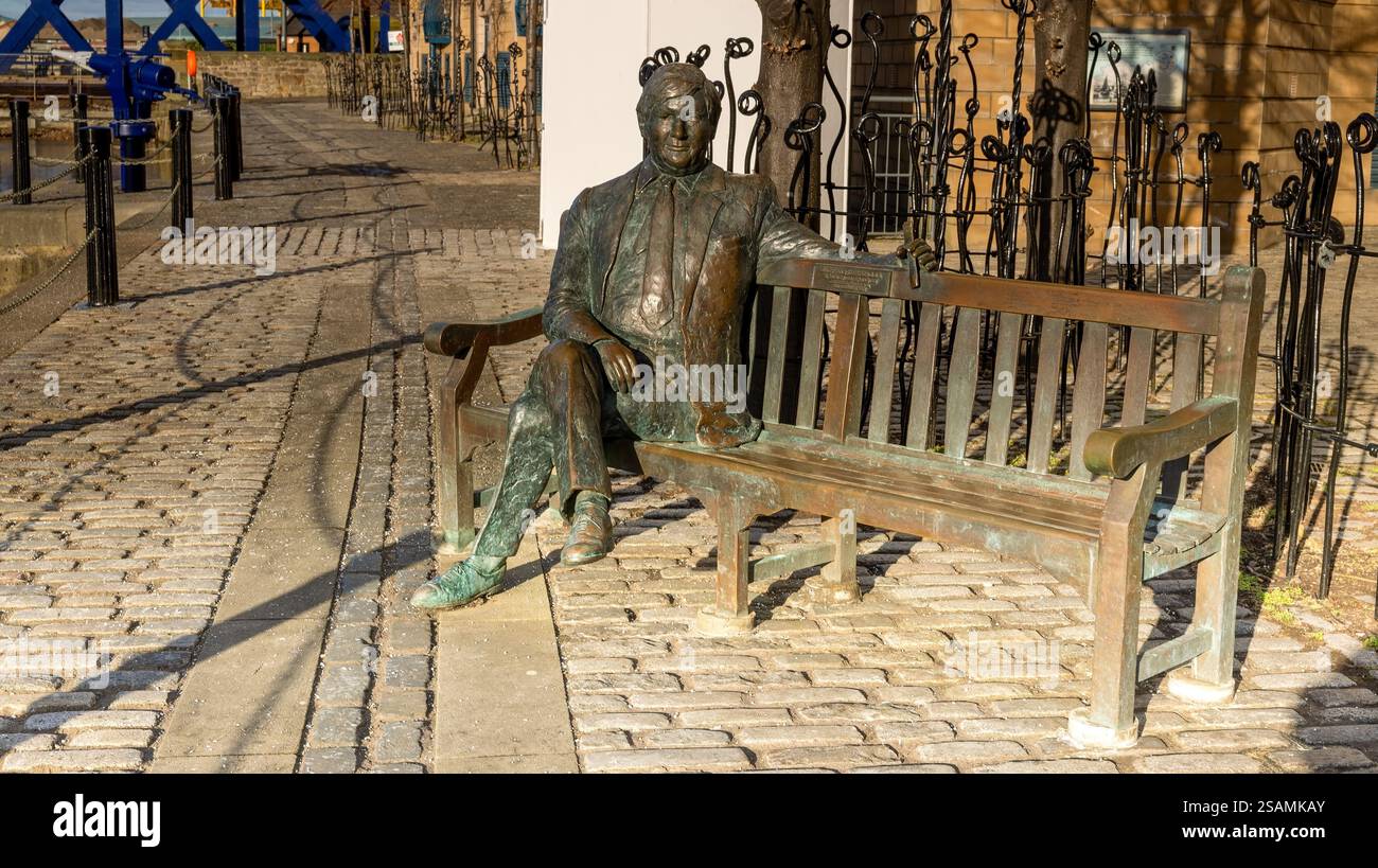 Statua di Sandy Irvine Robertson OBE seduta su una panchina a Leith, Edimburgo, Scozia, Regno Unito Foto Stock