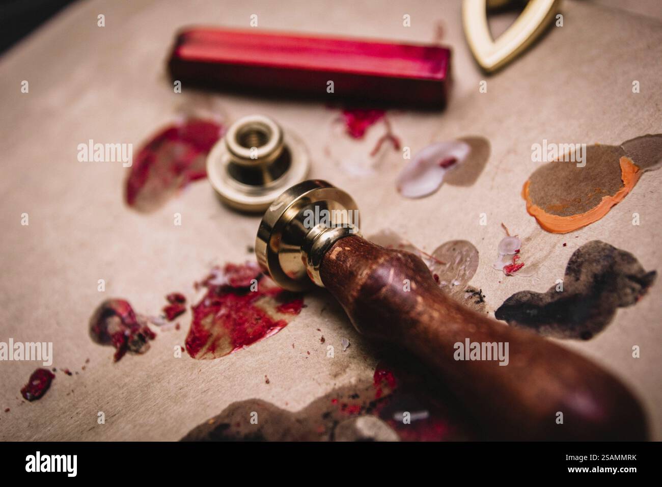 Primo piano di un sigillo di cera e pennellate di cera rossa su carta, mostrando un'atmosfera creativa e vintage Foto Stock