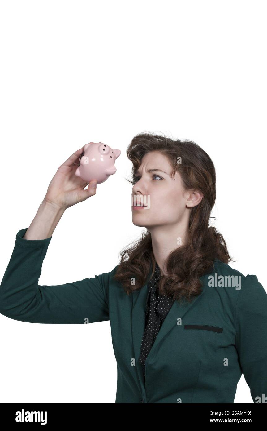 Bella donna che tiene un salvadanaio pieno di soldi che ha risparmiato Foto Stock