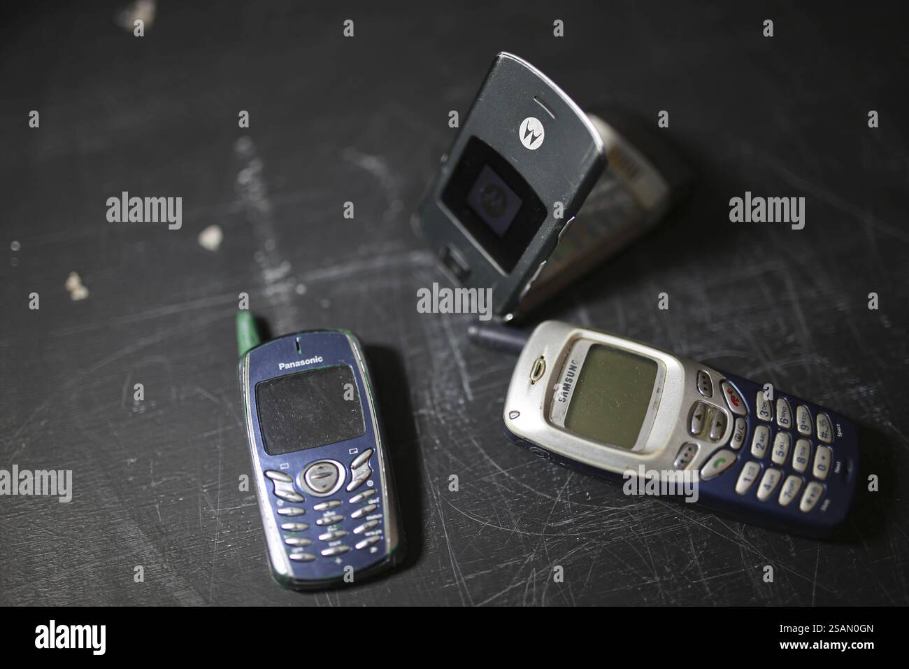 Telefoni cellulari retrò su una superficie scura, un telefono apribile si è aperto Foto Stock