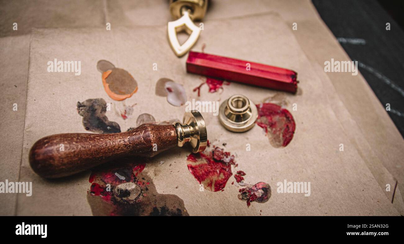 Set di guarnizioni vintage in cera con bastoncino di cera rosso su carta marrone, per creare un'atmosfera artistica Foto Stock