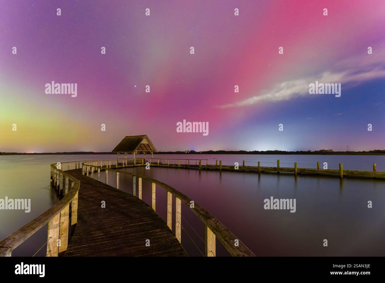 Molo in legno e aurora boreale / luci polari sul lago Hemmelsdorf / Hemmelsdorfer SEE vicino a Lübeck, Schleswig-Holstein, Germania Foto Stock
