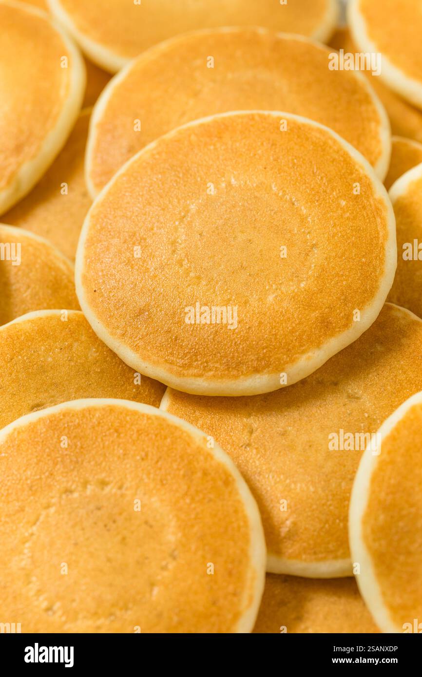 Mini pancake fatti in casa a forma di dollaro d'argento per colazione con burro e sciroppo Foto Stock