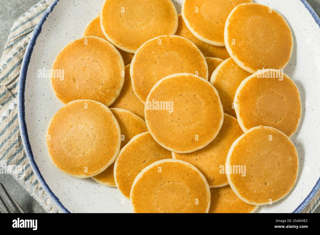 Mini pancake fatti in casa a forma di dollaro d'argento per colazione con burro e sciroppo Foto Stock