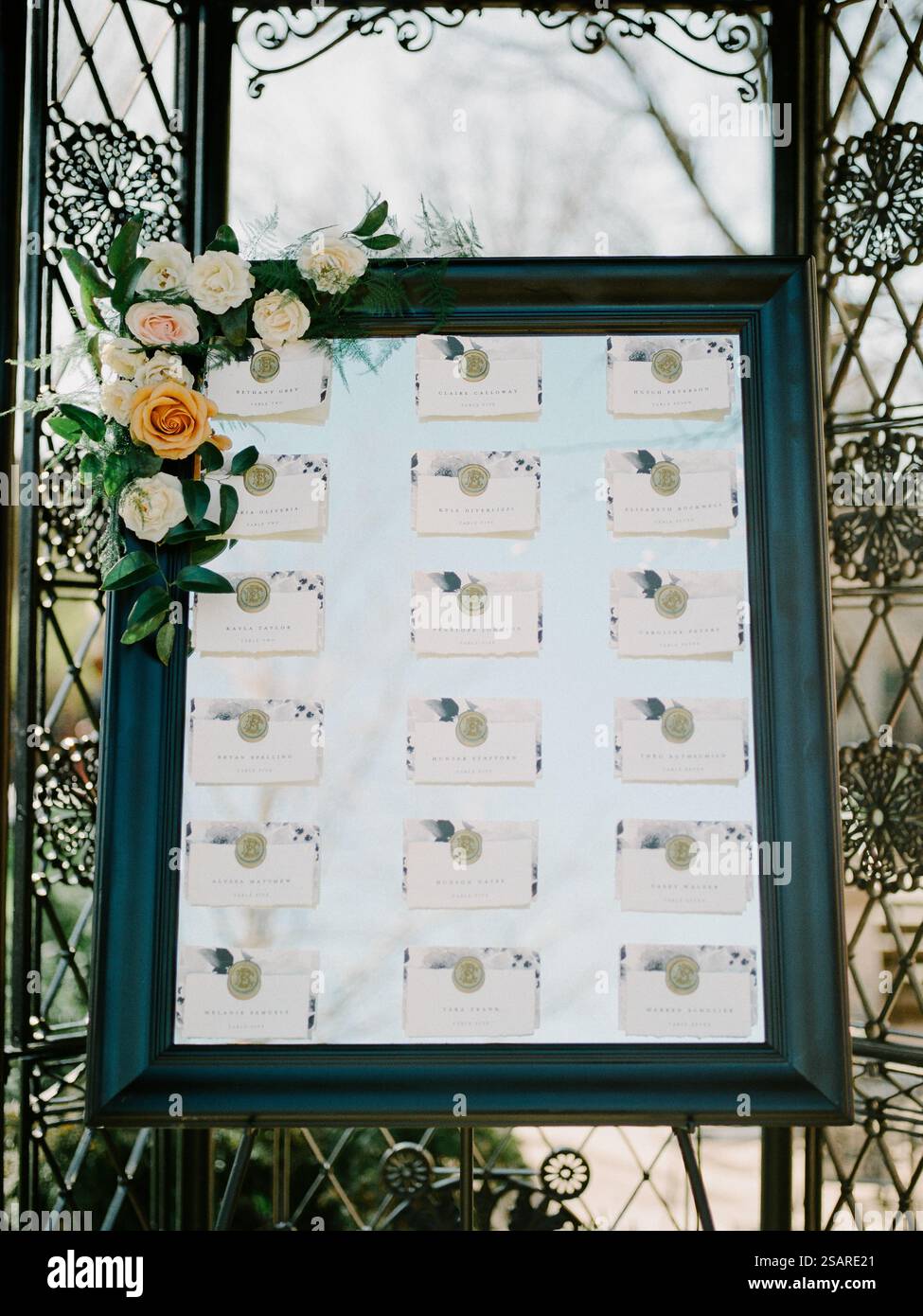 Una splendida tabella dei posti a sedere mostra i nomi degli ospiti e le assegnazioni dei tavoli, decorata con fiori freschi, creando un'atmosfera invitante per il Foto Stock