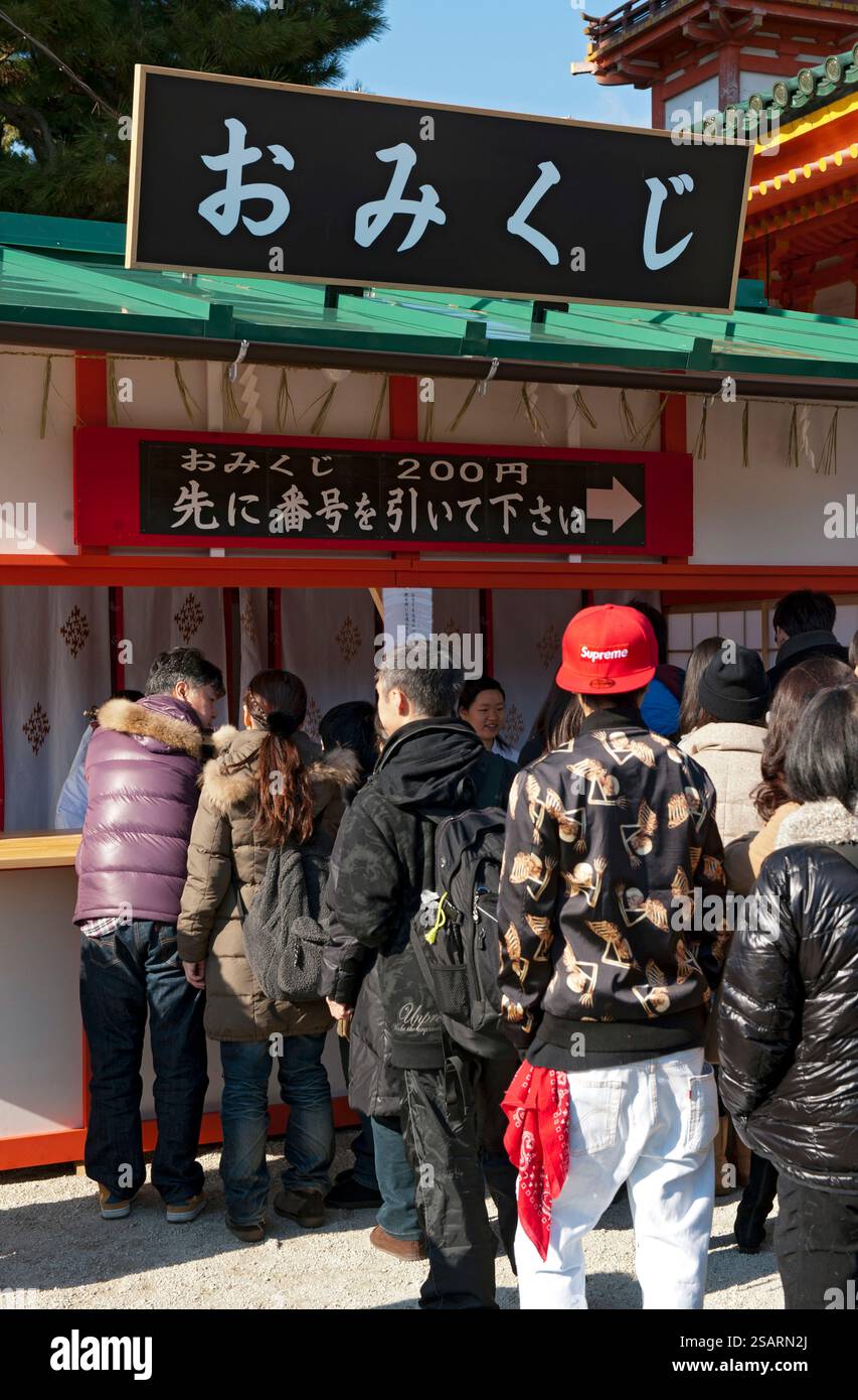 Persone in fila alla finestra 'omikuji' (oracolo di carta di buona o cattiva sorte) durante 'Hatsumode' (visita al santuario di Capodanno) a Heian Jingu a Kyoto. Foto Stock