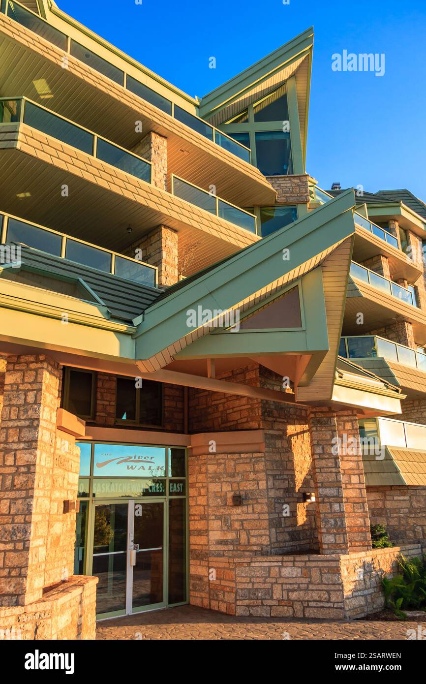 Un grande edificio con un tetto verde e una porta di vetro. L'edificio è un hotel. La porta è aperta e l'edificio è illuminato Foto Stock