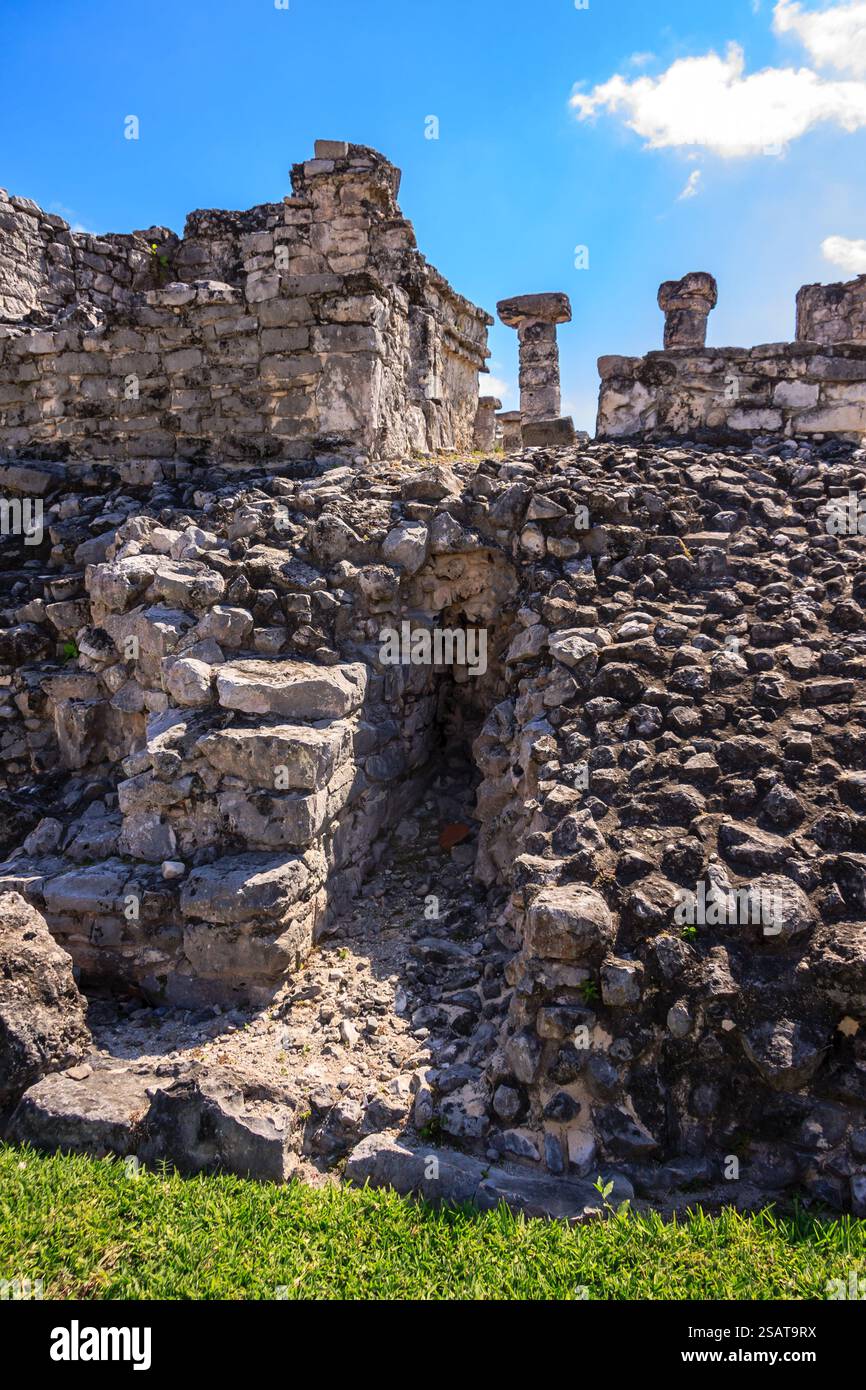Un edificio in pietra con una scala in pietra che vi porta. L'edificio e' circondato da erba e presenta un muro di pietra Foto Stock