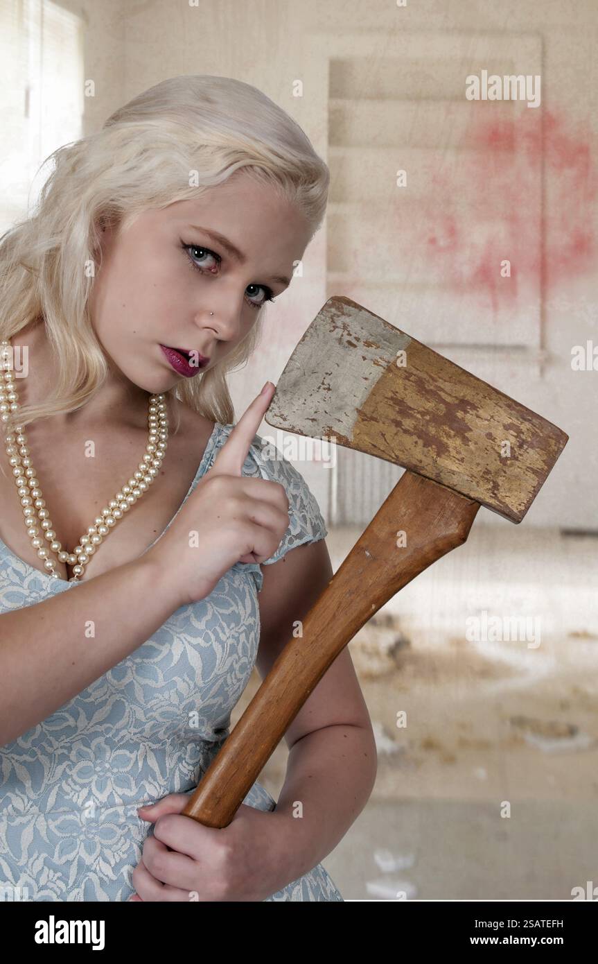 Bella donna posseduto in una trance di trattenimento di un ax Foto Stock