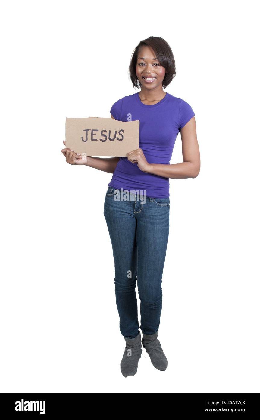 Una giovane e bella donna nera tenendo in mano un cartello di Gesù Foto Stock