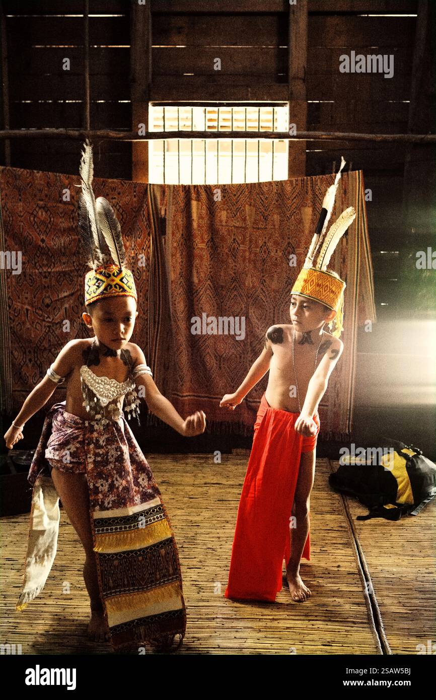 Bambini in abiti tradizionali che eseguono danza di benvenuto durante un evento di ecoturismo presso la casa di riposo della comunità tradizionale Dayak IBAN a Sungai Utik, Batu Lintang, Embaloh Hulu, Kapuas Hulu, West Kalimantan, Indonesia. Secondo la legge indonesiana sulla protezione dell'infanzia, numero 35/2014, il gruppo di bambini che dovrebbero ricevere una protezione speciale sono minoranze e bambini isolati; questo include i bambini indigeni che vivono per lo più in aree remote, ha scritto un team di scienziati guidati da mira Azzasyofia. Foto Stock