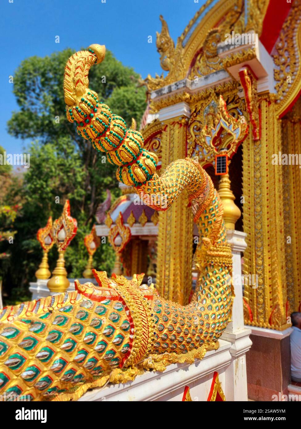 Tempio buddista tailandese dai colori vivaci che mostra l'architettura tradizionale, sculture dorate di Naga e sculture ornate in Thailandia. - Immagine stock catturata con smartphone