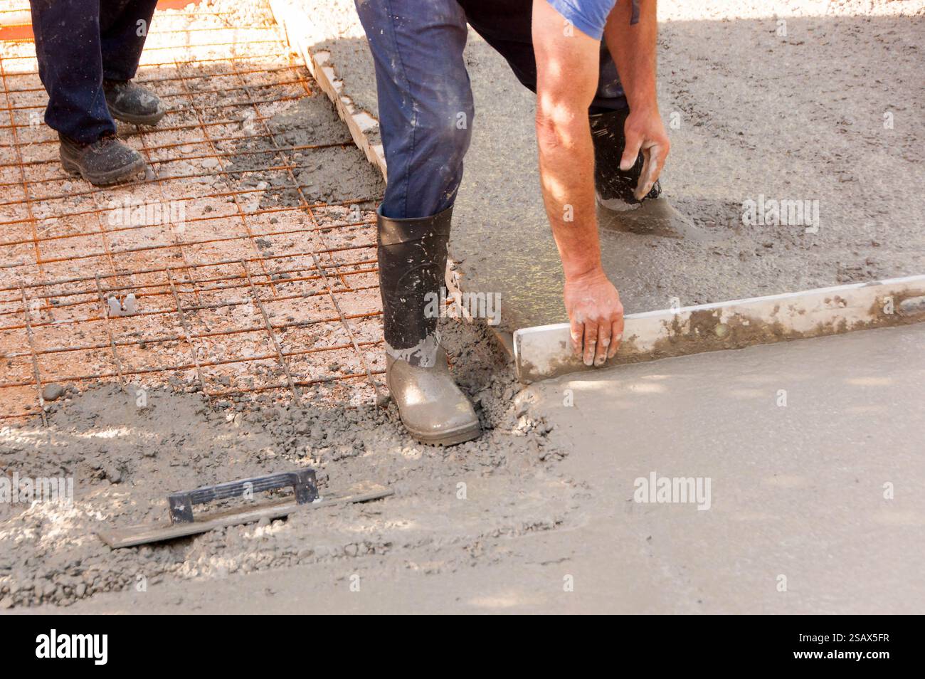I lavoratori lavorano in un parcheggio per calcestruzzo Foto Stock