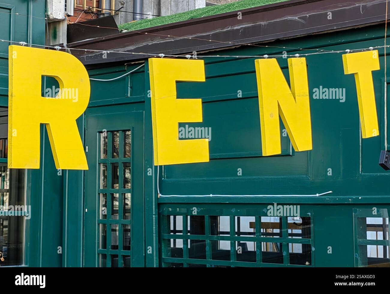 Noleggio: Cartello giallo sul telaio della porta verde Foto Stock
