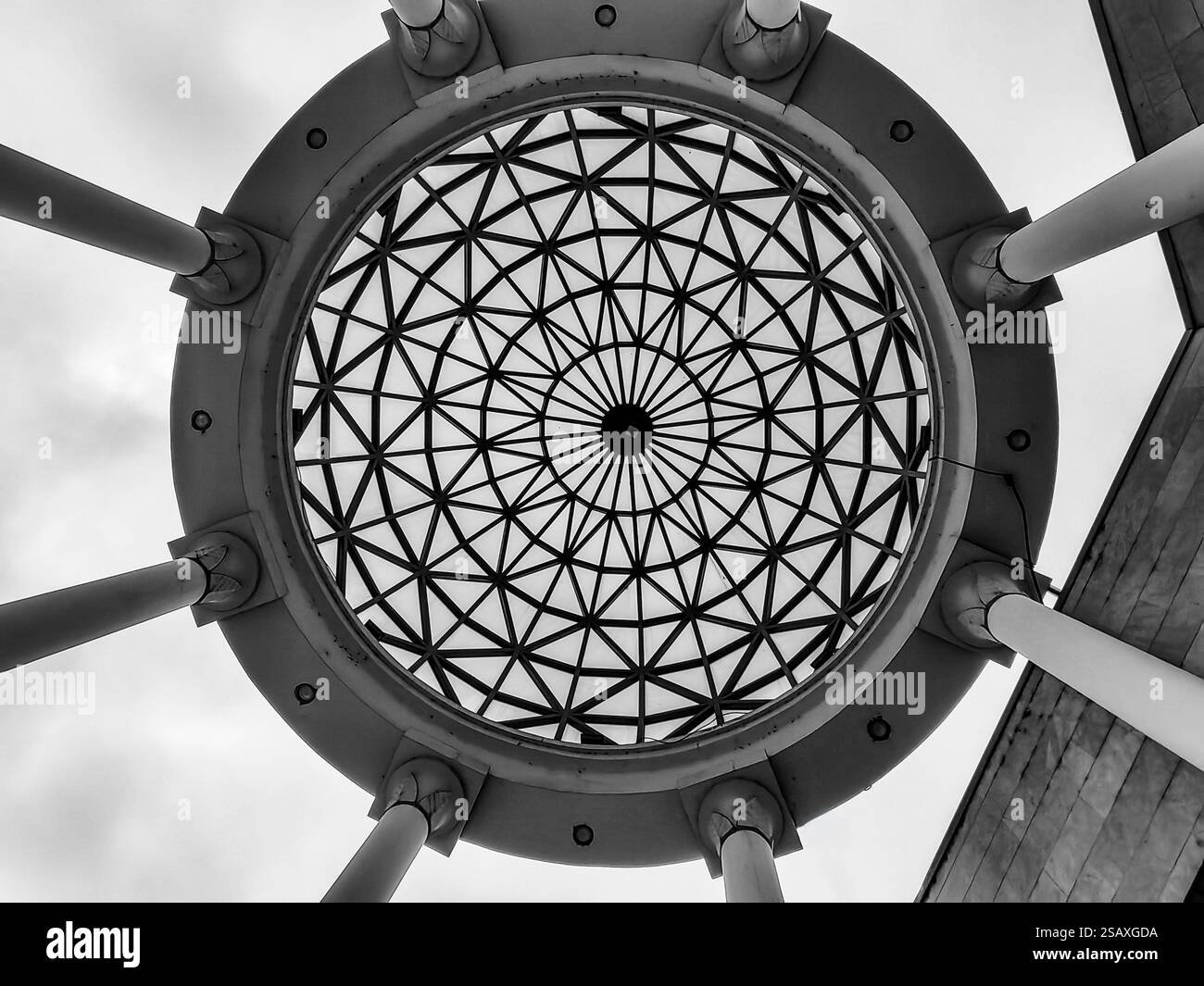 Cerchio ornamentale nel cielo: Tetto e pilastri di cemento da una prospettiva ad angolo basso Foto Stock