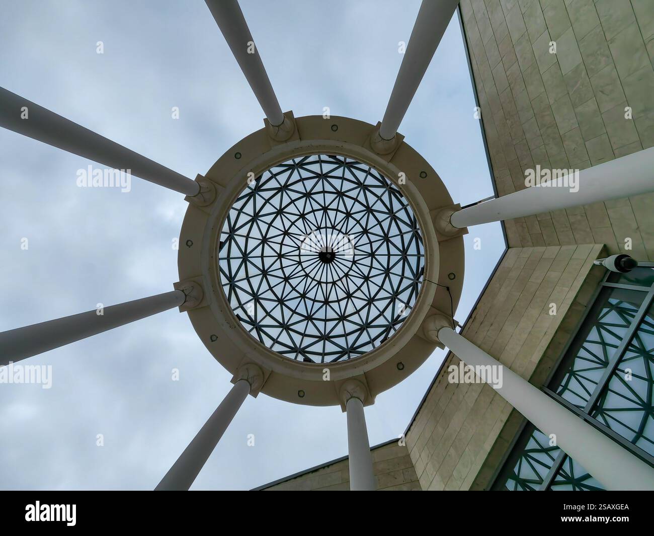 Cerchio ornamentale nel cielo: Tetto e pilastri di cemento da una prospettiva ad angolo basso Foto Stock
