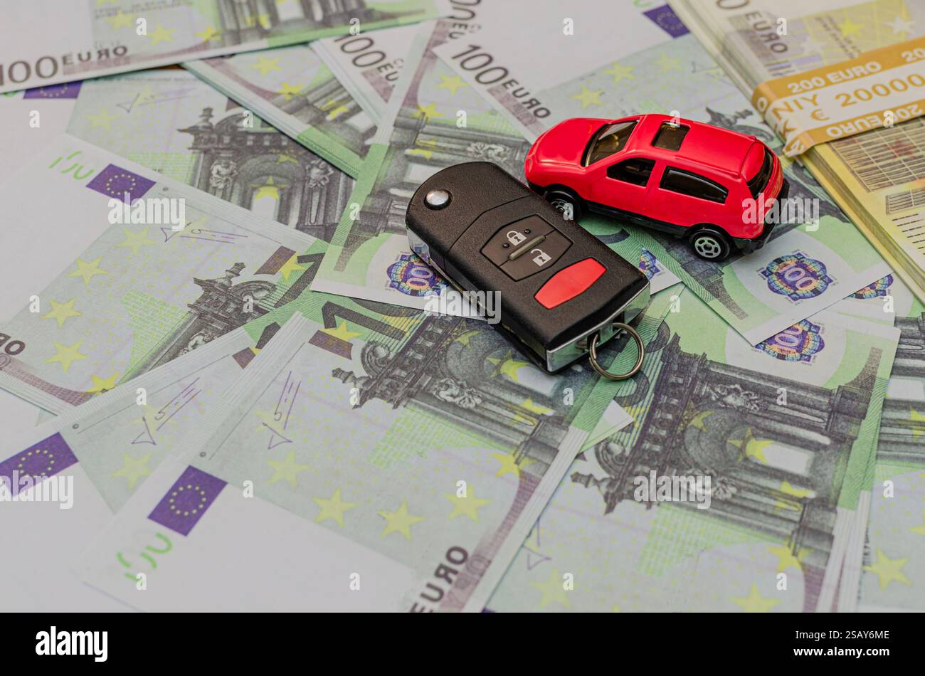 Chiave auto in euro e auto giocattolo rosso, assicurazione auto, vendita o noleggio Foto Stock