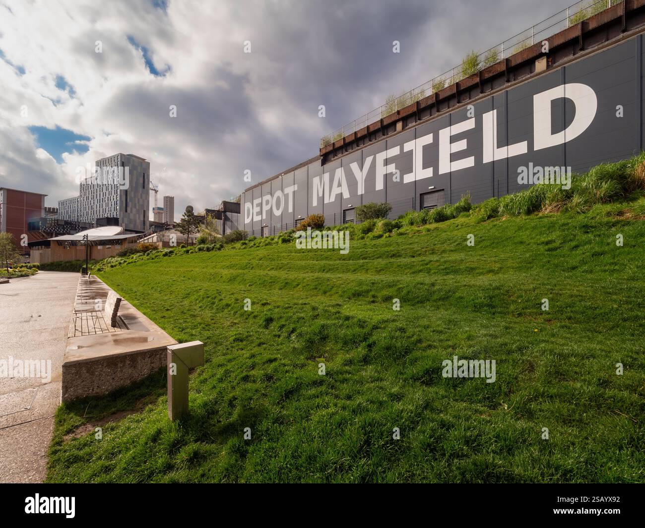 Mayfield Park ha fatto un passo sulla riva dell'erba con il Depot Mayfield alle spalle. Manchester Regno Unito Foto Stock