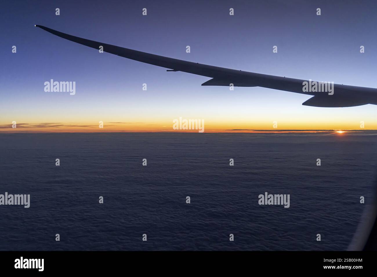 Vista del Golfo Persico dalla finestra dell'aereo in serata. Tramonto sulle nuvole. Volo con la compagnia aerea Etihad. Abu Dhabi, Emirato Arabo Unito Foto Stock