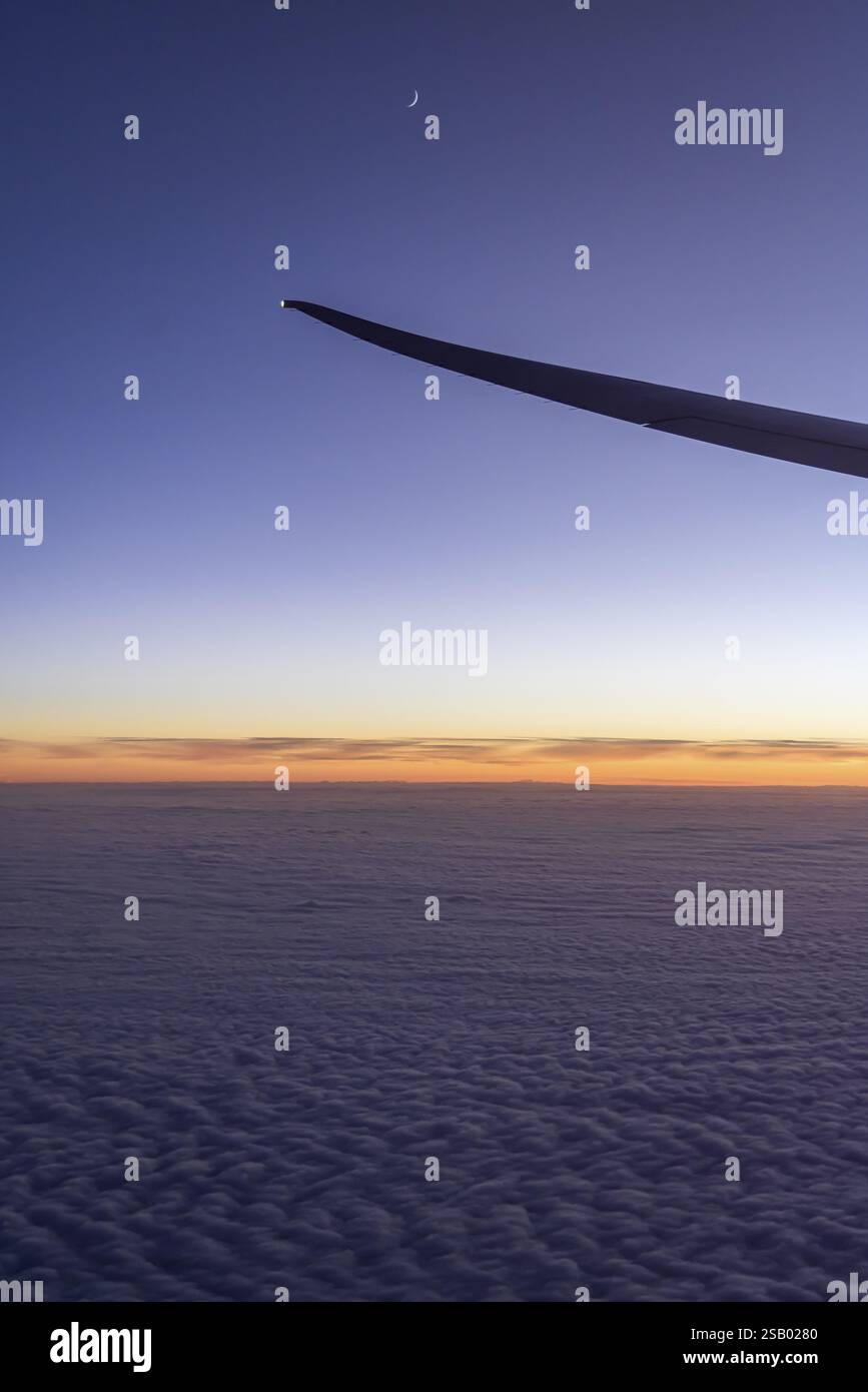 Vista del Golfo Persico dalla finestra dell'aereo in serata. Tramonto sulle nuvole. Volo con la compagnia aerea Etihad. Abu Dhabi, Emirato Arabo Unito Foto Stock