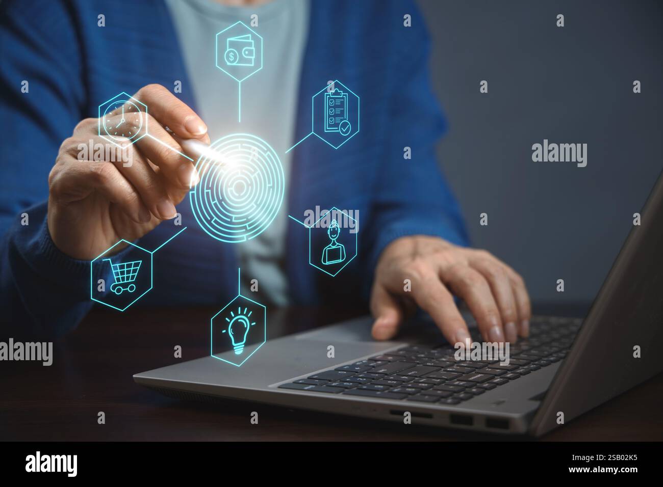 Una persona sta lavorando su un notebook, interagendo con le icone virtuali sullo schermo. Le icone rappresentano varie funzioni e strumenti. Strategia aziendale per Foto Stock