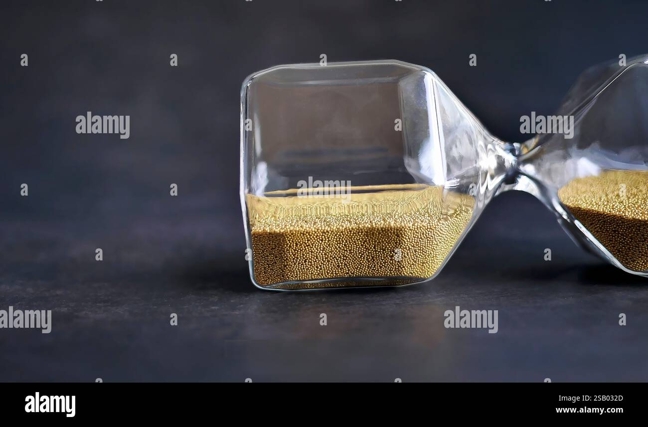 Primo piano lastra trasparente a clessidra con sabbia dorata, vetro di sabbia con sfondo scuro, Time Stop o Balance Time Concept, per la pubblicità Foto Stock