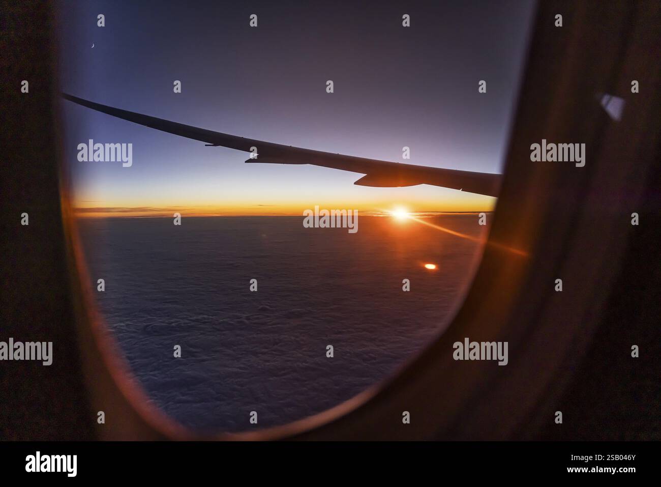 Vista del Golfo Persico dalla finestra dell'aereo in serata. Tramonto sulle nuvole. Volo con la compagnia aerea Etihad. Abu Dhabi, Emirato Arabo Unito Foto Stock