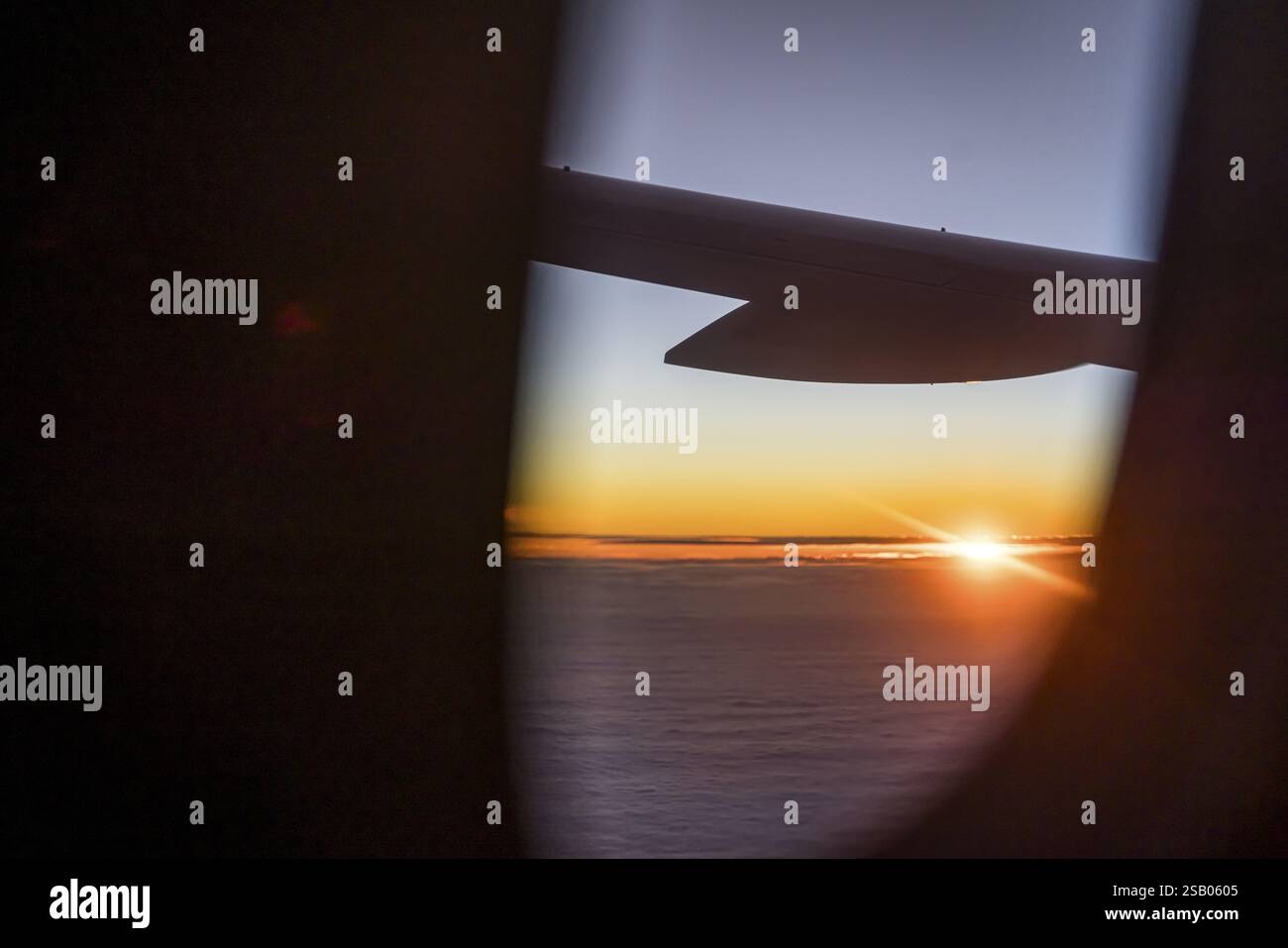 Vista del Golfo Persico dalla finestra dell'aereo in serata. Tramonto sulle nuvole. Volo con la compagnia aerea Etihad. Abu Dhabi, Emirato Arabo Unito Foto Stock
