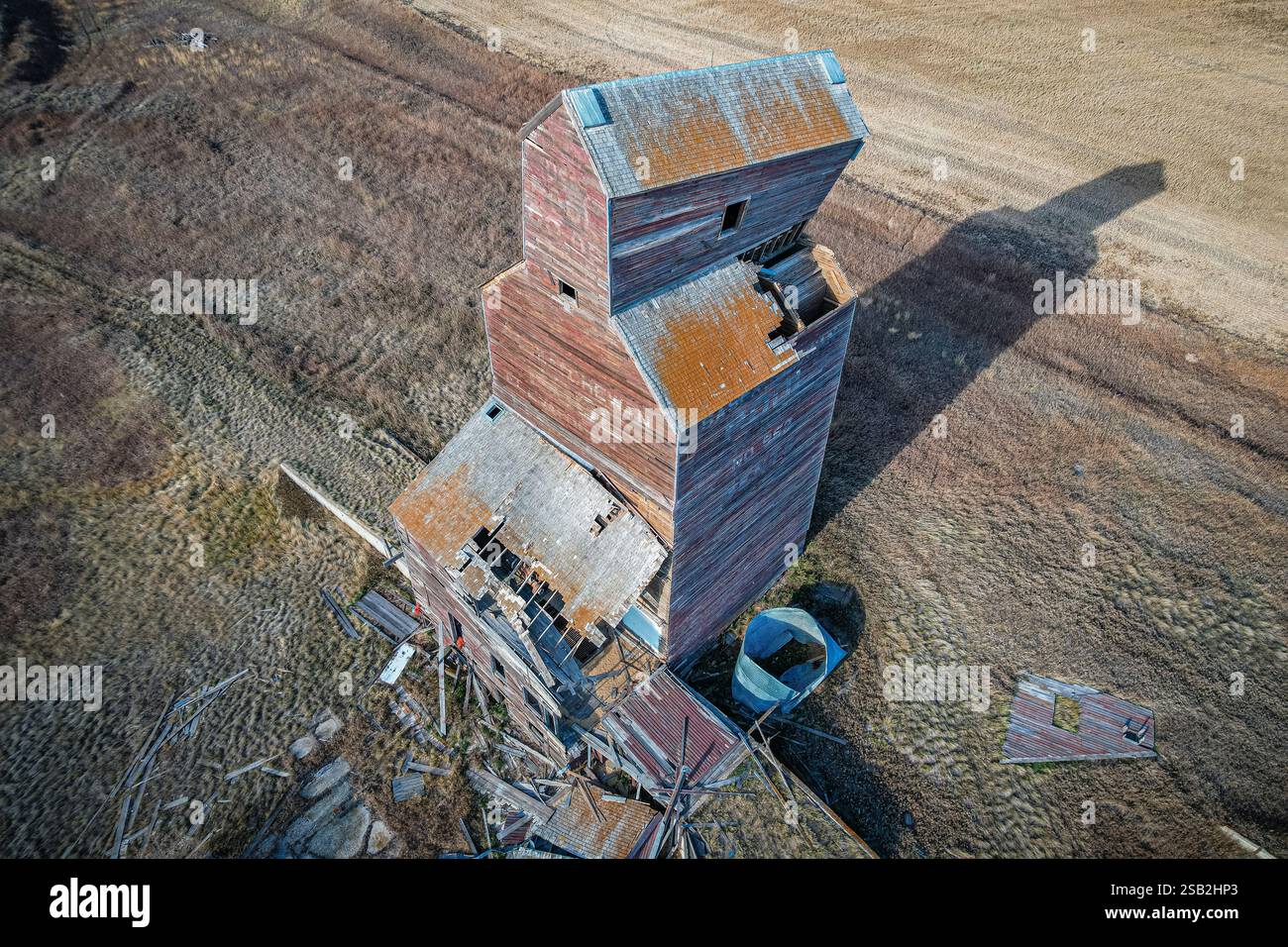 Un silo di grano e' nel mezzo di un campo. Il silo è vecchio e ha molta ruggine Foto Stock