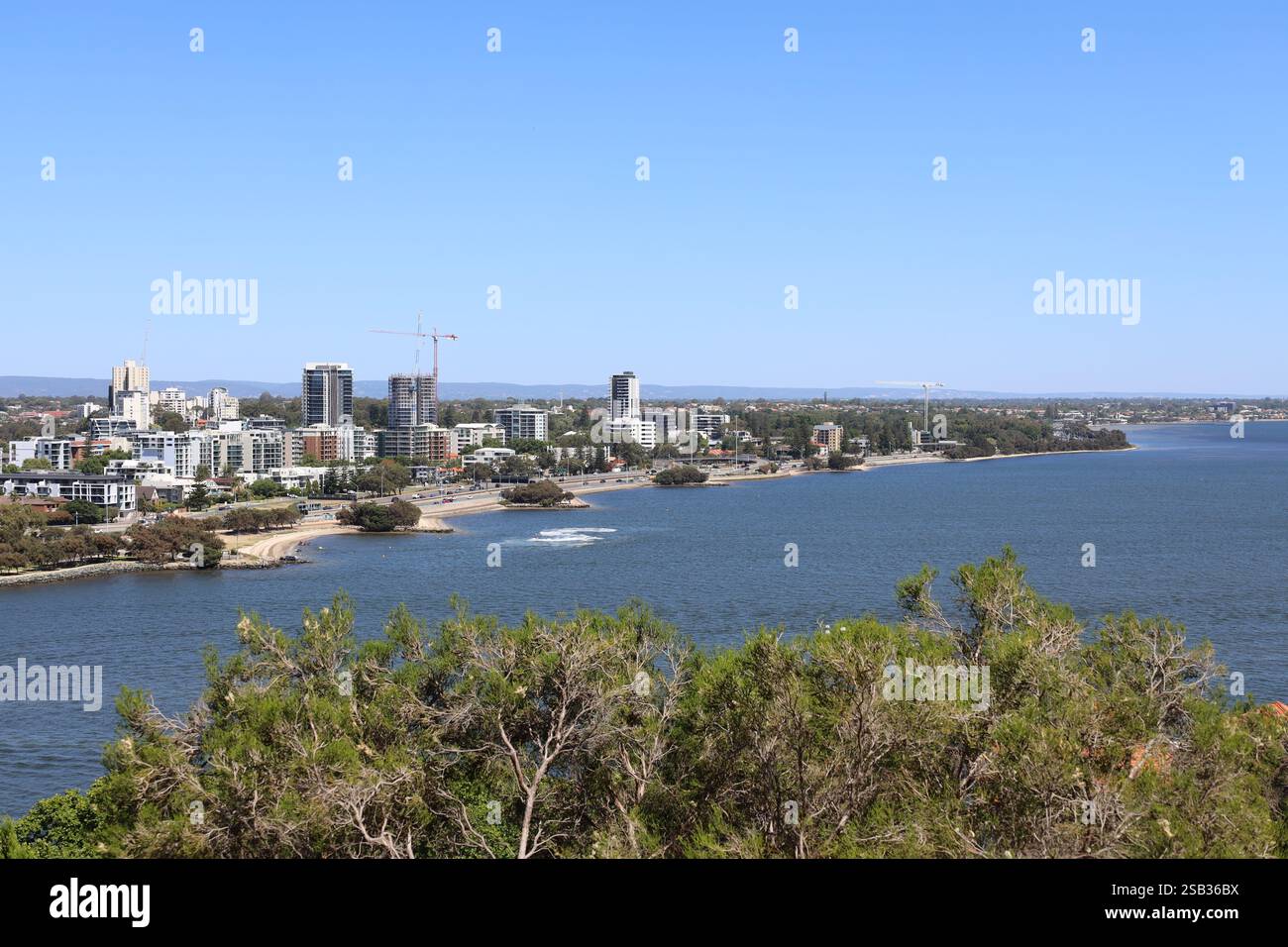 baia d'acqua blu accanto allo sviluppo urbano sotto un cielo blu profondo e limpido Foto Stock