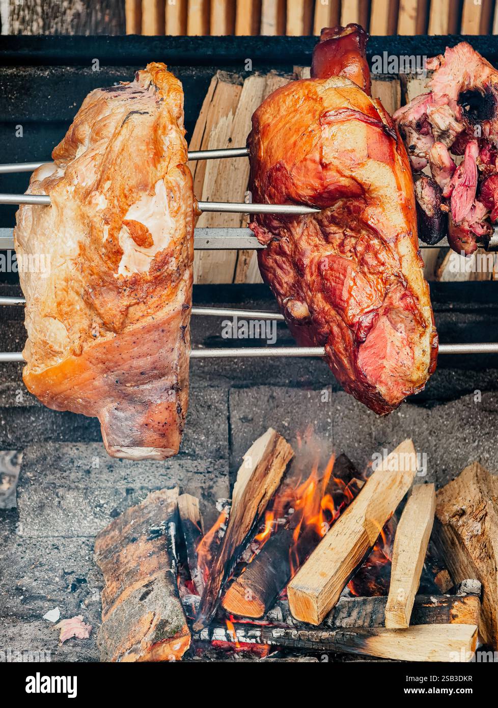 Carne grigliata allo spiedo sopra i carboni di un falò. Il cibo preferito di un vero uomo. Il piatto principale in compagnia degli uomini e a qualsiasi festa. Foto Stock