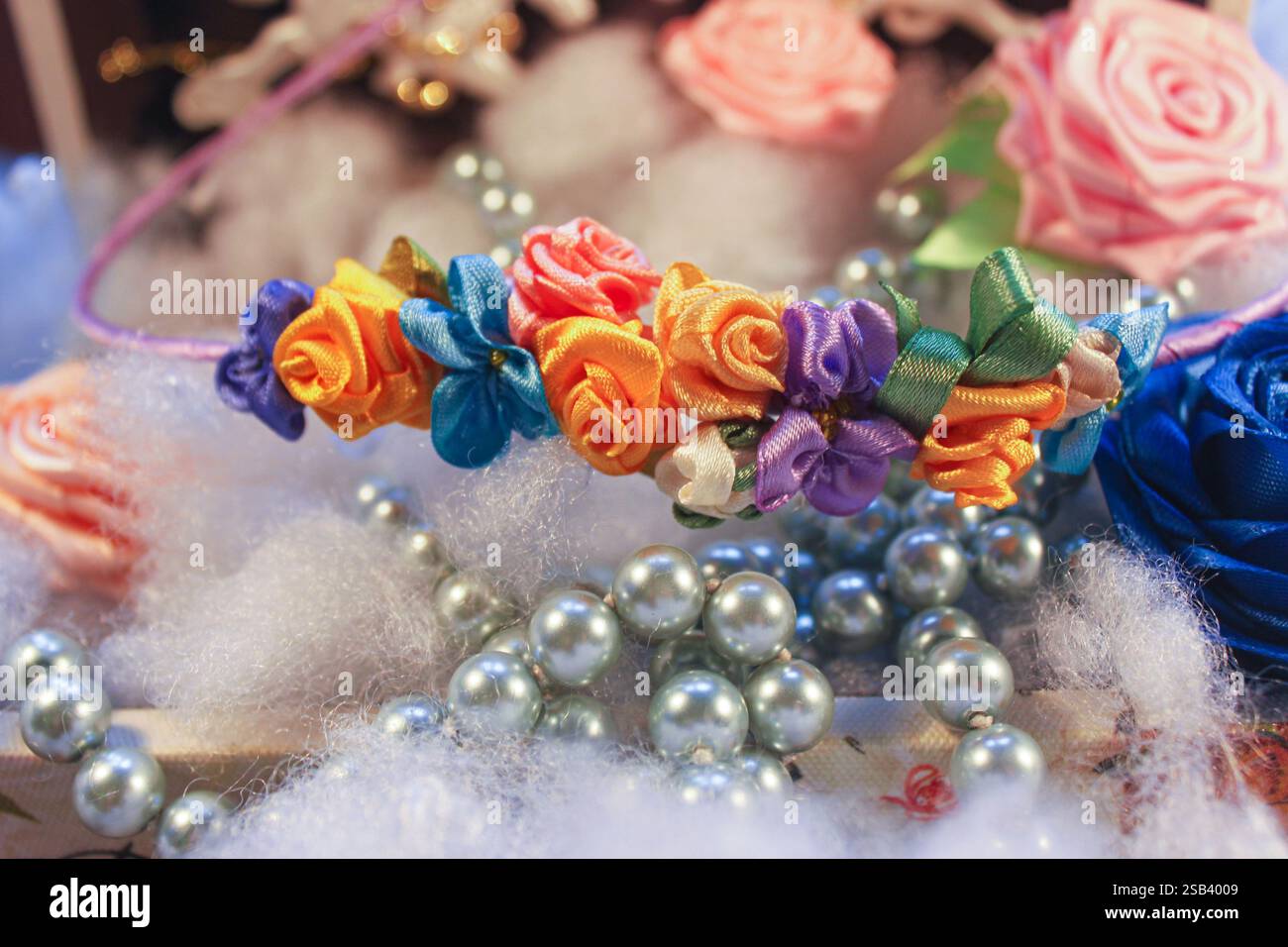 Scrivania di artigianato, decorazione per capelli - fiori fatti a mano da nastri, sfondo di imbottitura in poliestere e perle Foto Stock