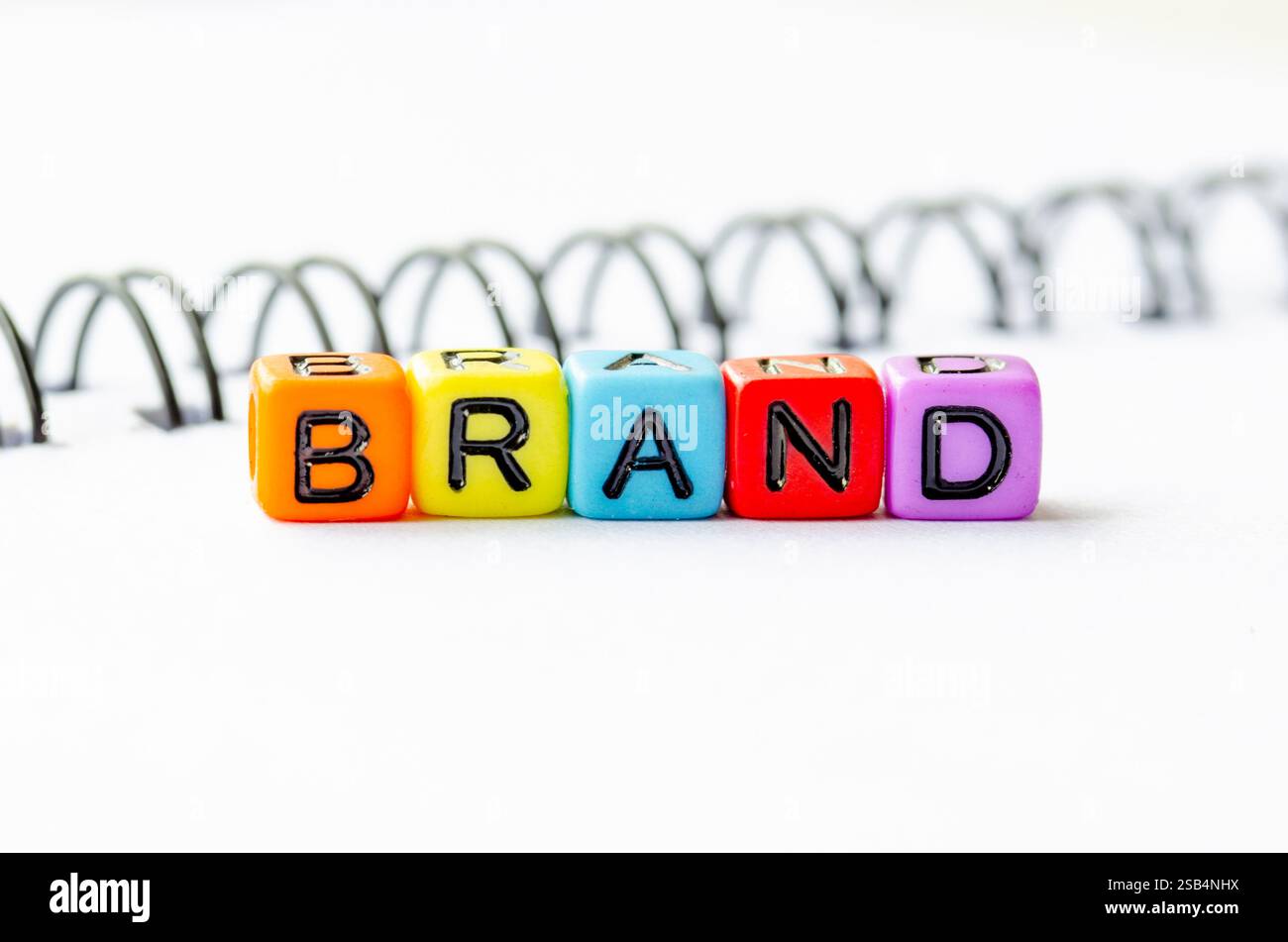 Testo del marchio su colorate perline alfabetiche in plastica. Branding e concetto di business. Foto Stock