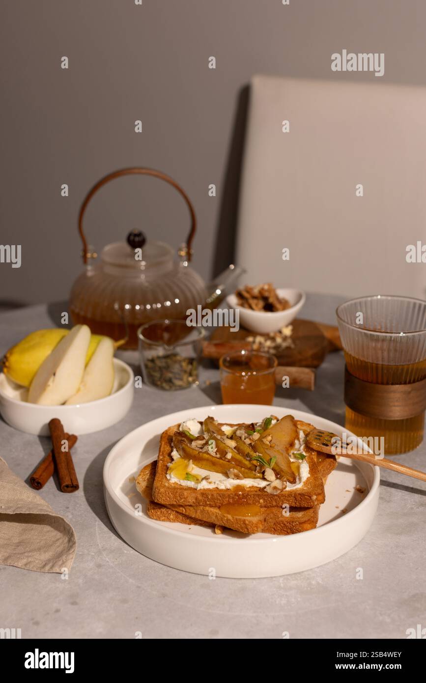 Colazione con toast al formaggio spalmabile e pere caramellate, miele e noci Foto Stock