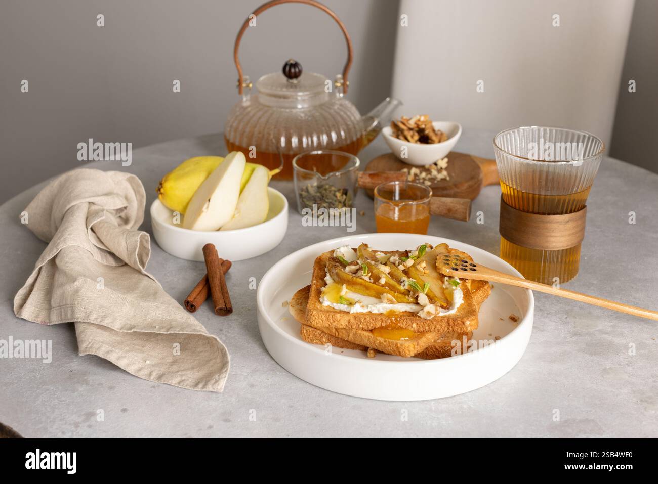 Colazione con toast al formaggio spalmabile e pere caramellate, miele e noci Foto Stock