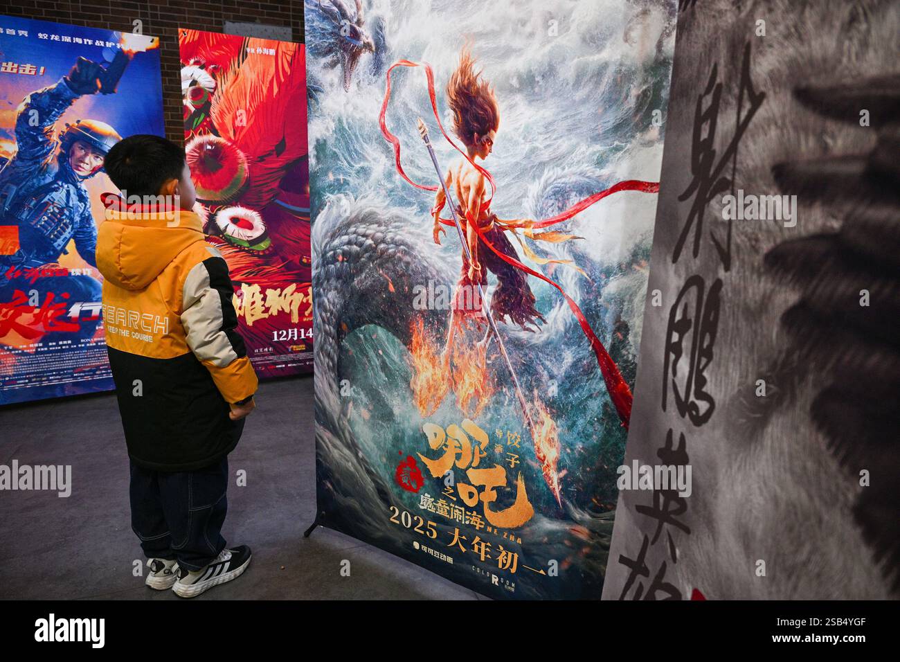 Un bambino guarda un poster di un film di Capodanno lunare cinese in un cinema a Nantong, nella provincia di Jiangsu, nella Cina orientale, 1 febbraio 2025. Foto Stock