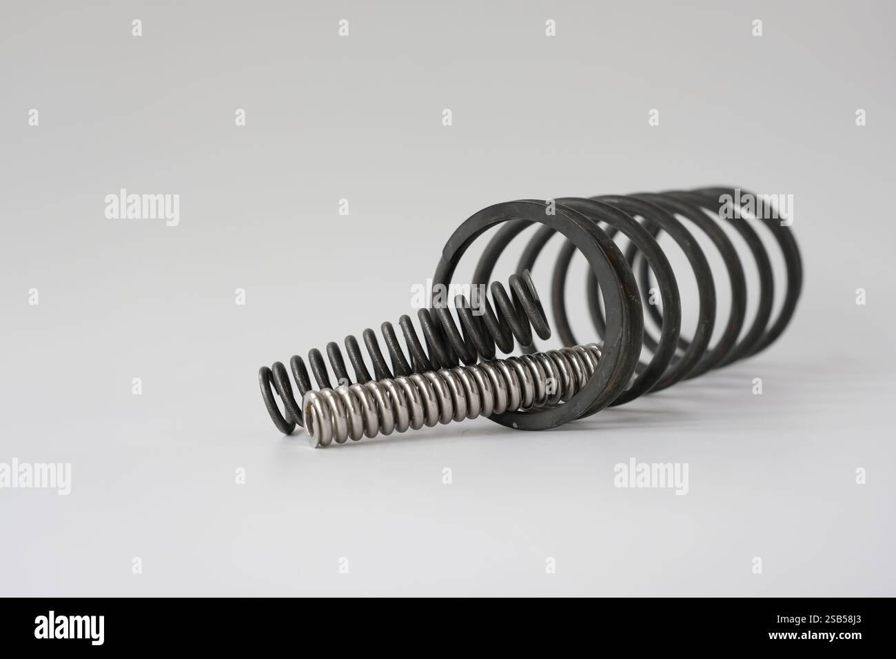 Molle metalliche di diametri diversi. Parti di ricambio nel settore della costruzione di macchine. Foto Stock