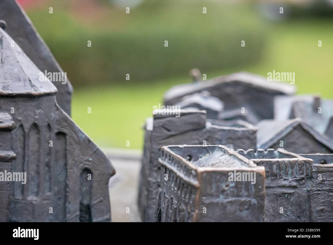per edifici in miniatura in metallo. Gli edifici sono di diverse forme e dimensioni e si trovano su una superficie verde. Foto Stock