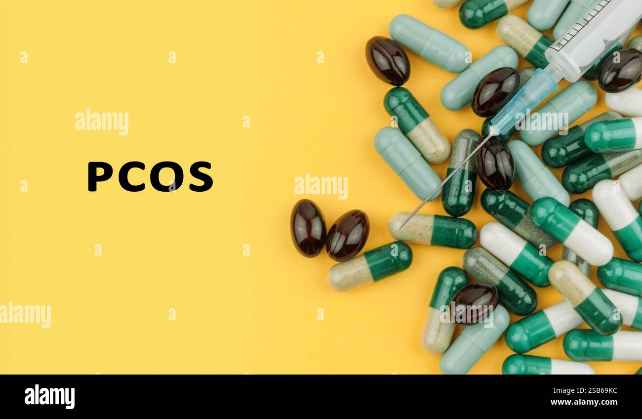 Mazzo di pillole con una siringa sopra di esse. Le pillole sono etichettate con la parola PCOS Foto Stock