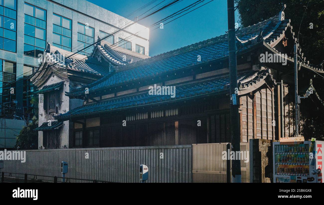 Un'antica residenza, probabilmente appartenente al monaco o custode del tempio Ryūkoku-ji a Taito Ward, Tokyo, Giappone, si trova in netto contrasto con lo splendore Foto Stock