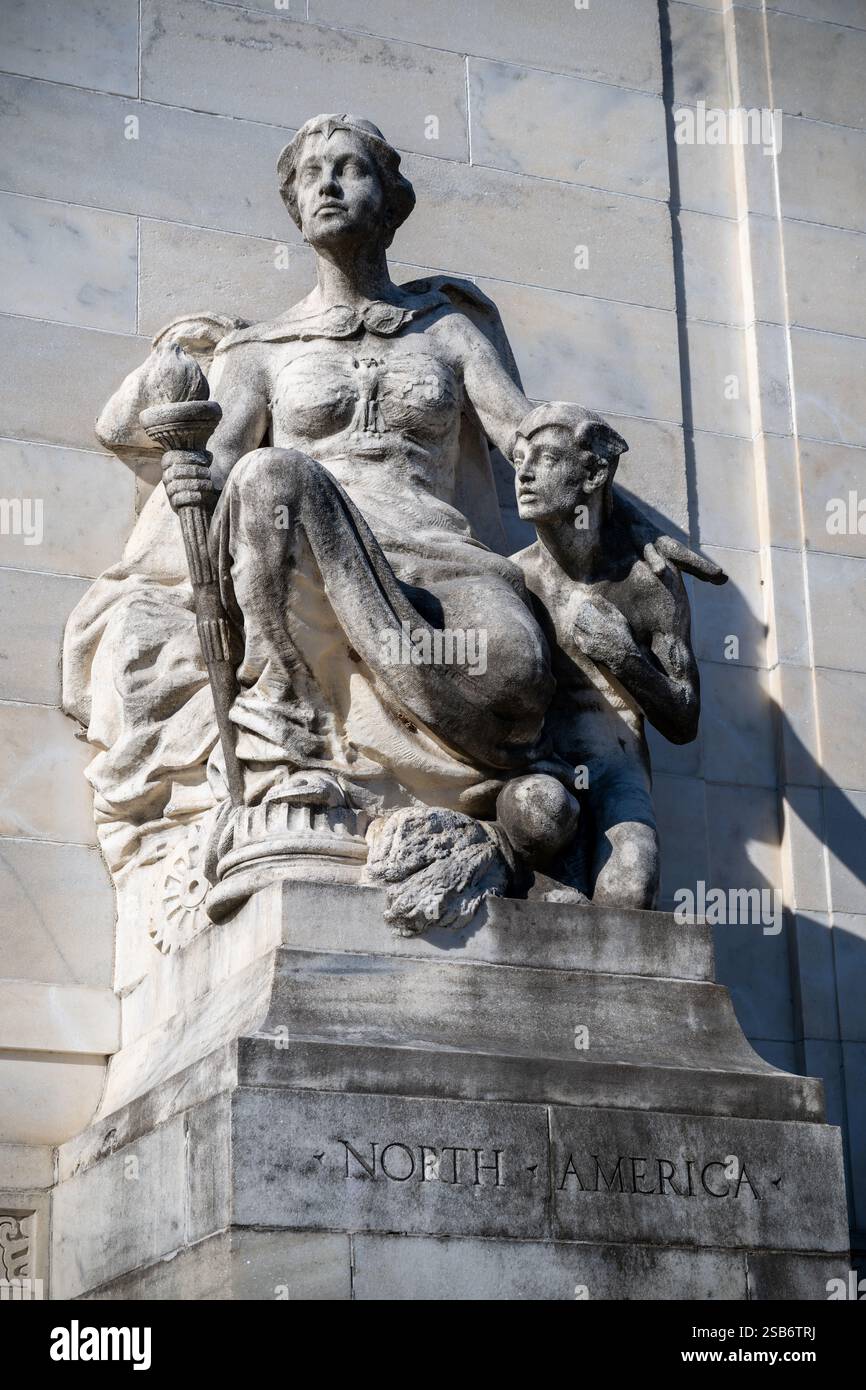 North America Sculpture Organization of American States Washington DC // WASHINGTON DC — la scultura allegorica in marmo "North America" di Gutzon Borglum si trova all'ingresso destro dell'Organization of American States Building. Creata nel 1910, la scultura raffigura una figura femminile drappeggiata che tiene in mano una torcia, accompagnata da un giovane vigile. La scultura si abbina al "Sud America" sul lato opposto, fiancheggiando le griglie d'ingresso in bronzo. Foto Stock
