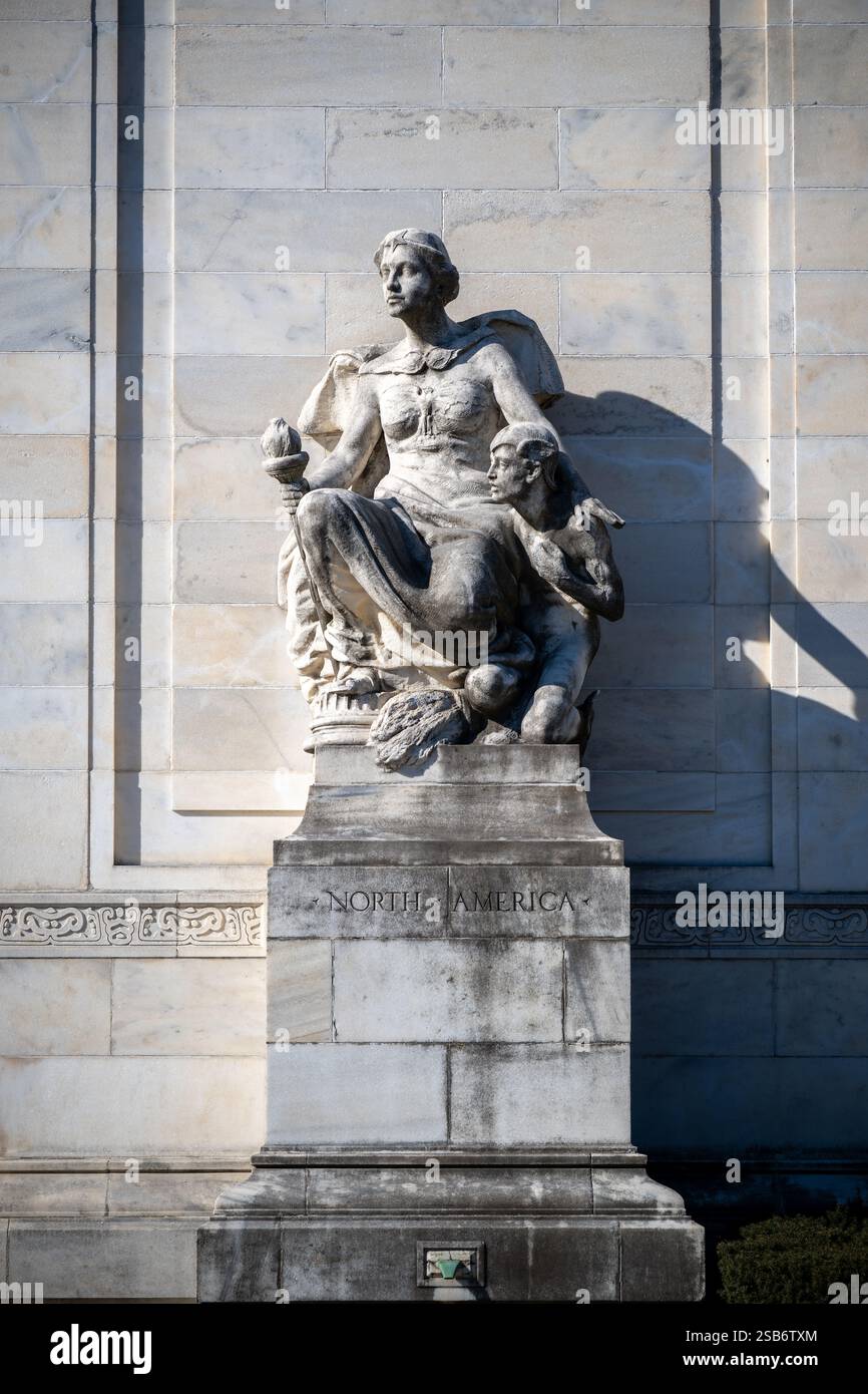 North America Sculpture Organization of American States Washington DC // WASHINGTON DC — la scultura allegorica in marmo "North America" di Gutzon Borglum si trova all'ingresso destro dell'Organization of American States Building. Creata nel 1910, la scultura raffigura una figura femminile drappeggiata che tiene in mano una torcia, accompagnata da un giovane vigile. La scultura si abbina al "Sud America" sul lato opposto, fiancheggiando le griglie d'ingresso in bronzo. Foto Stock