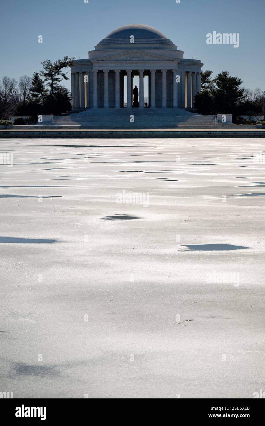 WASHINGTON DC - Ice Covers the Tidal Basin il 29 gennaio 2025, con il Jefferson Memorial visibile sullo sfondo. Il monumento neoclassico si erge contro il paesaggio invernale. La superficie ghiacciata del bacino delle maree crea un netto contrasto con il marmo bianco del monumento. Foto Stock