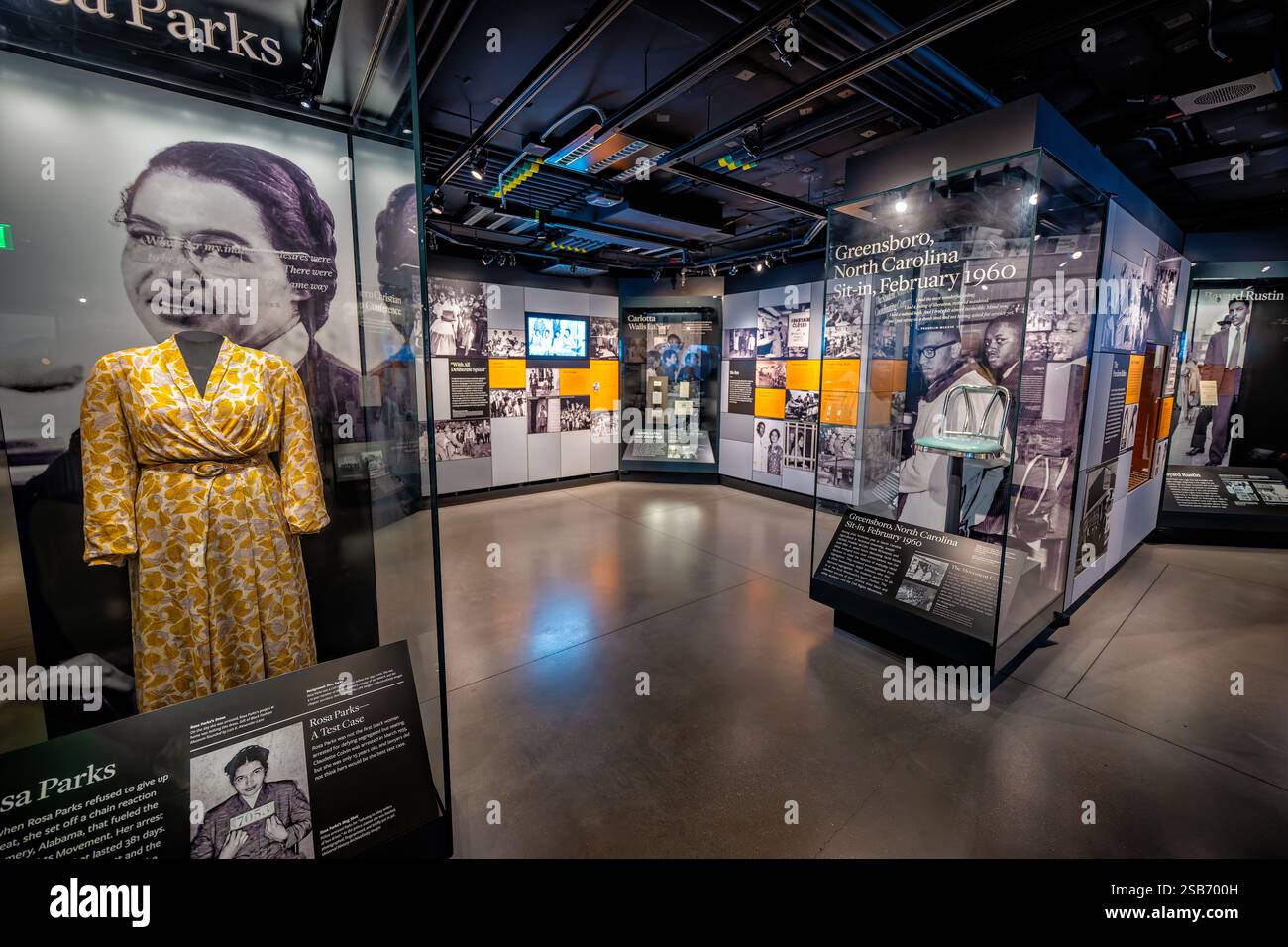 WASHINGTON DC - il National Museum of African American History and Culture espone l'abito giallo di Rosa Parks accanto a una sedia del 1960 di Greensboro al banco pranzo di Woolworth. Questi manufatti rappresentano due momenti cruciali nella storia dei diritti civili: Il rifiuto di Parks del 1955 di rinunciare al suo posto in autobus a Montgomery, Alabama, e le proteste non violente contro il bancone del pranzo che hanno scatenato un'ondata di sit-in in tutto il Sud. Foto Stock