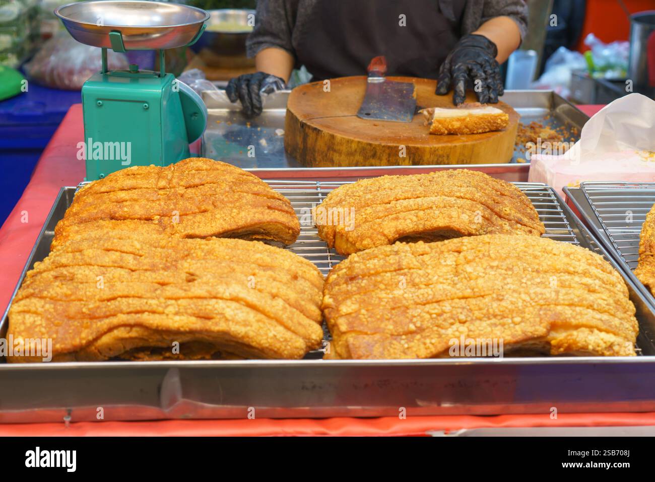 Vista ravvicinata di croccanti fette di pancetta di maiale cotte alla perfezione, con crosta dorata e carne tenera. Il piatto salato viene visualizzato su un tra Foto Stock
