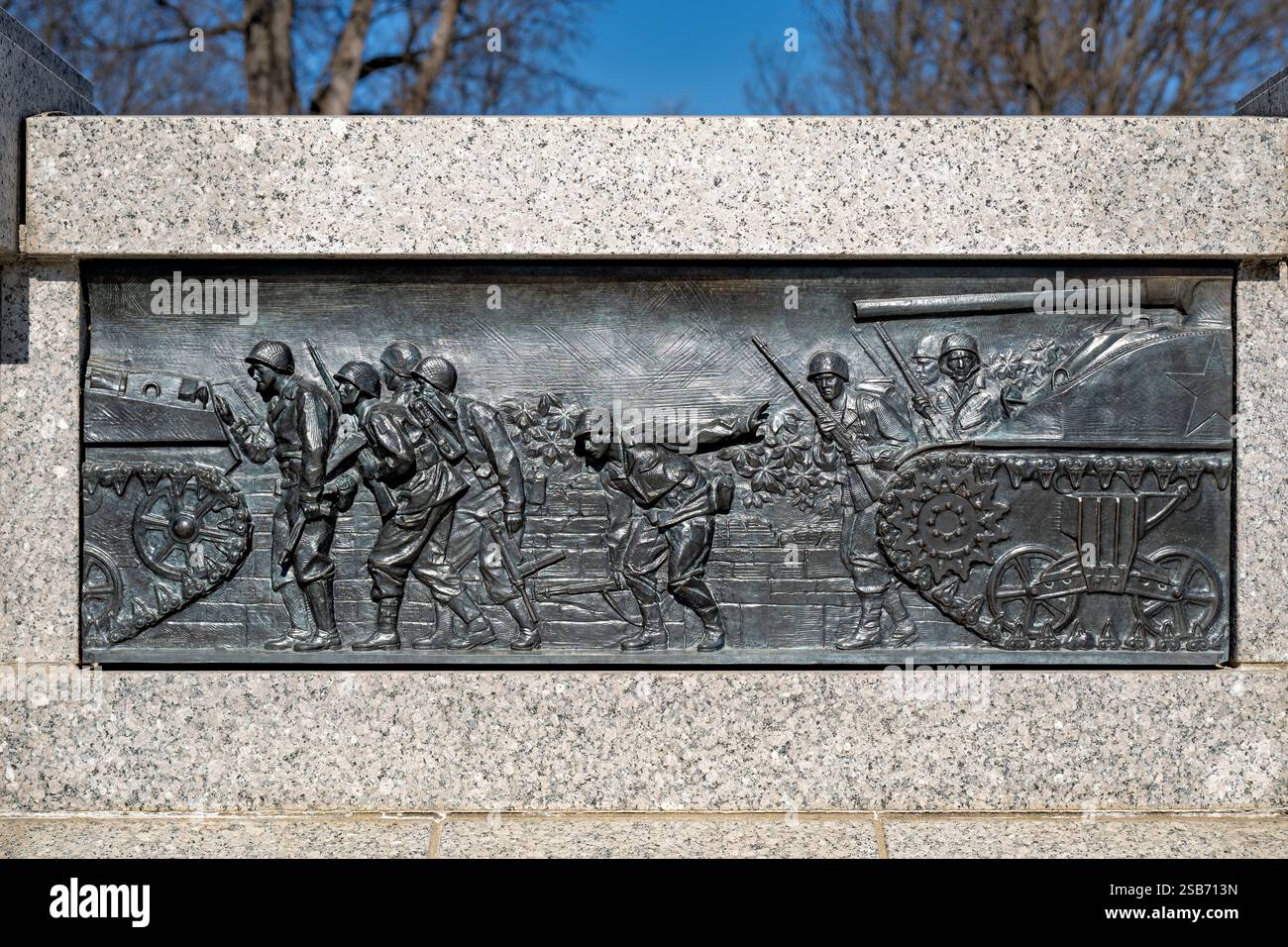 Monumento della Seconda Guerra Mondiale sul National Mall di Washington DC | WASHINGTON DC — Il bassorilievo in bronzo "Carri armati in combattimento" al National World War II Memorial raffigura carri armati americani M4 Sherman che supportano la fanteria durante l'avanzata alleata attraverso la Francia. Creato dallo scultore Ray Kaskey, questa opera d'arte è uno dei 24 pannelli in bronzo che illustrano sia scene di battaglia che scene del fronte interno lungo l'ingresso cerimoniale del monumento. Sebbene superati dai carri armati tedeschi in potenza di fuoco e protezione, lo Sherman si è rivelato decisivo grazie al volume di produzione e all'affidabilità meccanica, e ha svolto un ruolo centrale nelle forze alleate Foto Stock