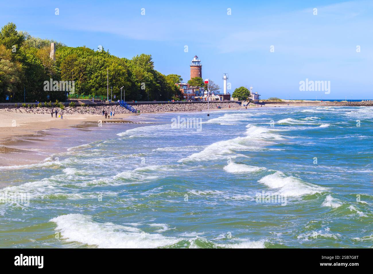 Splendida spiaggia nella città di Kolobrzeg con faro in lontananza, costa del Mar Baltico, Polonia Foto Stock