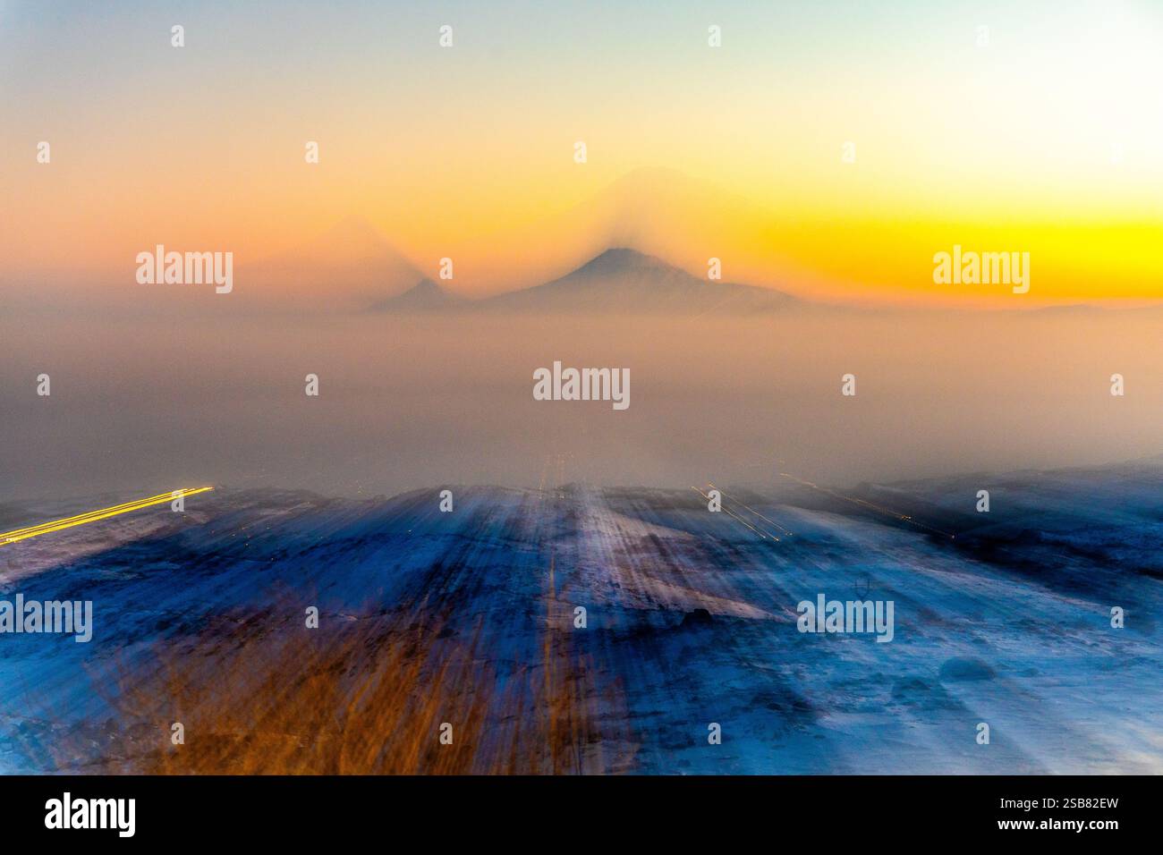 Una vista affascinante del Monte Ararat al tramonto, catturata dal Monte Aragats, con colori vivaci e nebbia atmosferica che fondono il paesaggio Foto Stock
